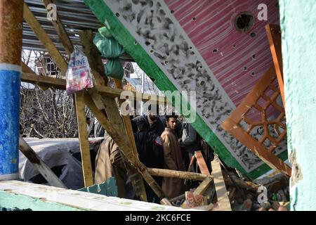 Menschen in Kashmiri beurteilen das beschädigte Wohnhaus im Dorf Kanigam im Bezirk Shopian, südlich von Srinagar, im indischen Kaschmir, am 26. Dezember 2020. Bei einem nächtlichen Treffen wurden zwei lokale kashmiritische Millitanten getötet und zwei indische paramilitärische Truppen verletzt. (Foto von Muzamil Mattoo/NurPhoto) Stockfoto