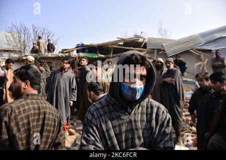 Menschen in Kashmiri beurteilen das beschädigte Wohnhaus im Dorf Kanigam im Bezirk Shopian, südlich von Srinagar, im indischen Kaschmir, am 26. Dezember 2020. Bei einem nächtlichen Treffen wurden zwei lokale kashmiritische Millitanten getötet und zwei indische paramilitärische Truppen verletzt. (Foto von Muzamil Mattoo/NurPhoto) Stockfoto