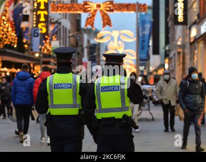 Zwei Garda-Offiziere sahen am St. Stephen's Day Patrouillen auf der Henry Street im Stadtzentrum von Dublin. Taoiseach Micheal Martin kündigte am 22.. Dezember eine Reihe neuer Level-5-Beschränkungen an, die die Ausbreitung des Coronavirus eindämmen sollen. Dazu gehören Beschränkungen der Personenbesatzung und die Öffnung aller nicht unbedingt notwendigen Einzelhandelsgeschäfte (Geschäfte können zwar geöffnet bleiben, müssen aber die Umsätze im Januar verschieben). Das Gesundheitsministerium meldete heute einen neuen täglichen Rekord von neuen Fällen für die Republik Irland mit 1.296 neuen Fällen und 6 Todesfällen (2.294 neue Fälle und 26 bestätigte Todesfälle auf der Insel Irland). Stockfoto