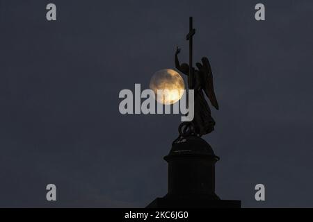 Die Statue eines Engels auf der Alexander-Säule auf dem Palastplatz in der Nähe des Aufstiegs des Vollmondes in St. Petersburg, Russland, am 28. Dezember 2020. (Foto von Sergey Nikolaev/NurPhoto) Stockfoto