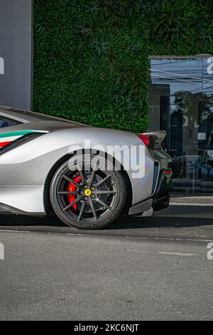 Vertikale Seitenansicht eines grauen Ferrari 488 Pista mit italienischer Flagge Stockfoto