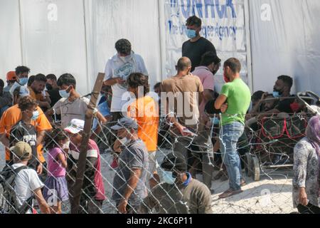 Neues provisorisches Flüchtlingslager in Kara Tepe - Mavrovouni mit großen weißen Zelten mit dem UNHCR- oder UNICEF-Logo und Asylbewerbern, die auf die Registrierung warten und Vorräte wie Nahrung, Betten, Kleidung usw. vom Haupteingang aus gesehen haben. Das neue eingezäunte Lager ist ein ehemaliges Militärgebiet, Schießplatz der Hellenischen Armee, in der Nähe der Stadt Mytilene auf der Insel Lesbos in Griechenland. Das neue Lager wurde nach dem Brand vom 9. September 2020 gegründet, als eines der größten Flüchtlingslager Europas, das Moria-Flüchtlingslager (Aufnahme-, Identifikations- und Registrierungszentrum), verbrannt wurde. Alle Bewohner, die Asyl suchen Stockfoto