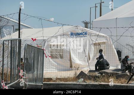 Neues provisorisches Flüchtlingslager in Kara Tepe - Mavrovouni mit großen weißen Zelten mit dem UNHCR- oder UNICEF-Logo und Asylbewerbern, die auf die Registrierung warten und Vorräte wie Nahrung, Betten, Kleidung usw. vom Haupteingang aus gesehen haben. Das neue eingezäunte Lager ist ein ehemaliges Militärgebiet, Schießplatz der Hellenischen Armee, in der Nähe der Stadt Mytilene auf der Insel Lesbos in Griechenland. Das neue Lager wurde nach dem Brand vom 9. September 2020 gegründet, als eines der größten Flüchtlingslager Europas, das Moria-Flüchtlingslager (Aufnahme-, Identifikations- und Registrierungszentrum), verbrannt wurde. Alle Bewohner, die Asyl suchen Stockfoto