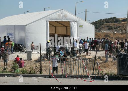 Neues provisorisches Flüchtlingslager in Kara Tepe - Mavrovouni mit großen weißen Zelten mit dem UNHCR- oder UNICEF-Logo und Asylbewerbern, die auf die Registrierung warten und Vorräte wie Nahrung, Betten, Kleidung usw. vom Haupteingang aus gesehen haben. Das neue eingezäunte Lager ist ein ehemaliges Militärgebiet, Schießplatz der Hellenischen Armee, in der Nähe der Stadt Mytilene auf der Insel Lesbos in Griechenland. Das neue Lager wurde nach dem Brand vom 9. September 2020 gegründet, als eines der größten Flüchtlingslager Europas, das Moria-Flüchtlingslager (Aufnahme-, Identifikations- und Registrierungszentrum), verbrannt wurde. Alle Bewohner, die Asyl suchen Stockfoto