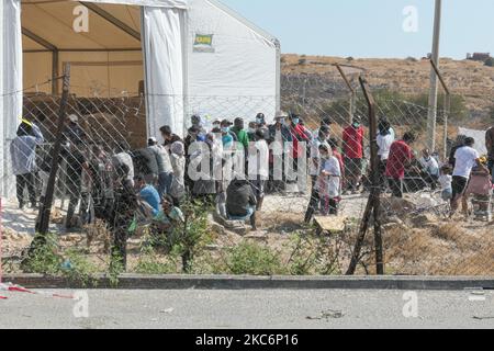 Neues provisorisches Flüchtlingslager in Kara Tepe - Mavrovouni mit großen weißen Zelten mit dem UNHCR- oder UNICEF-Logo und Asylbewerbern, die auf die Registrierung warten und Vorräte wie Nahrung, Betten, Kleidung usw. vom Haupteingang aus gesehen haben. Das neue eingezäunte Lager ist ein ehemaliges Militärgebiet, Schießplatz der Hellenischen Armee, in der Nähe der Stadt Mytilene auf der Insel Lesbos in Griechenland. Das neue Lager wurde nach dem Brand vom 9. September 2020 gegründet, als eines der größten Flüchtlingslager Europas, das Moria-Flüchtlingslager (Aufnahme-, Identifikations- und Registrierungszentrum), verbrannt wurde. Alle Bewohner, die Asyl suchen Stockfoto