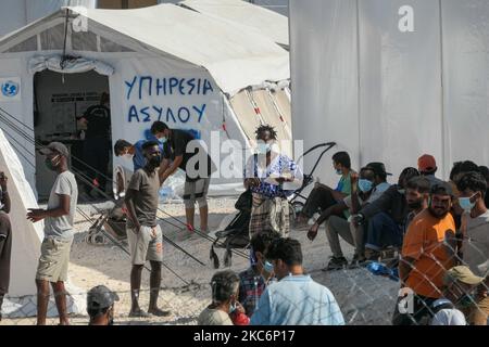 Neues provisorisches Flüchtlingslager in Kara Tepe - Mavrovouni mit großen weißen Zelten mit dem UNHCR- oder UNICEF-Logo und Asylbewerbern, die auf die Registrierung warten und Vorräte wie Nahrung, Betten, Kleidung usw. vom Haupteingang aus gesehen haben. Das neue eingezäunte Lager ist ein ehemaliges Militärgebiet, Schießplatz der Hellenischen Armee, in der Nähe der Stadt Mytilene auf der Insel Lesbos in Griechenland. Das neue Lager wurde nach dem Brand vom 9. September 2020 gegründet, als eines der größten Flüchtlingslager Europas, das Moria-Flüchtlingslager (Aufnahme-, Identifikations- und Registrierungszentrum), verbrannt wurde. Alle Bewohner, die Asyl suchen Stockfoto