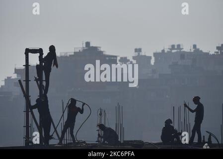 Eine Silhouette-Ansicht indischer Wanderarbeiter, die am Donnerstag, dem 31. Dezember 2020, in Kirtipur, Kathmandu, Nepal, in einem Neubau arbeiten. (Foto von Narayan Maharjan/NurPhoto) Stockfoto