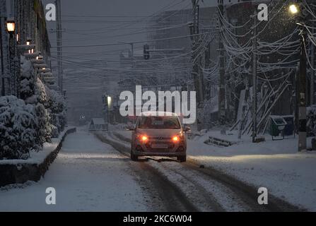 Ein Auto fährt auf schneebedeckter Straße, während es in Srinagar am 03. Januar 2021 schneit. Das Indian Meteorological Department hat moderaten Schneefall in Kaschmir und starken Schneefall in höheren Reichweiten vorhergesagt. Die 270 Kilometer lange Srinagar-Jammu-Autobahn die einzige Straße, die Kaschmir mit anderen Teilen des Landes verbindet, wurde nach frischem Schneefall gesperrt. Mindestens fünfzehn Personen wurden bei verschiedenen Verkehrsunfällen in Jammu und Kaschmir aufgrund rutschiger Straßen verletzt, berichtete eine lokale Nachrichtenagentur. (Foto von Faisal Khan/NurPhoto) Stockfoto