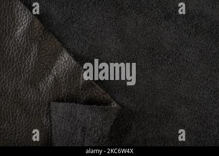 Nahaufnahme aus schwarzem Wildleder. Natürliche schwarze Wildleder-Textur für Design oder Projekt. Leder-Rückseite aus Samt. Stockfoto