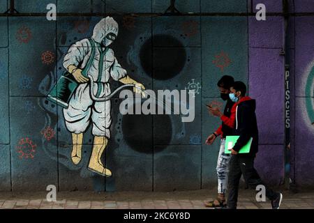 Am 4. Januar 2021 laufen die Menschen an einem Bewusstseinsbild auf Covid-19 entlang der Straße in Neu-Delhi vorbei. Indien verzeichnete in den 24 Stunden 16.505 neue Covid-19-Fälle, was die Gesamtzahl der Infektionen auf über 10,3 Millionen erhöht. (Foto von Mayank Makhija/NurPhoto) Stockfoto