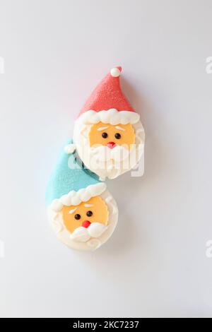 Zwei süße Desserts in Form eines Weihnachtsmannkopfes, mit einer roten und blauen Kappe Stockfoto