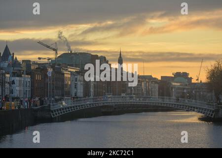 Blick auf das Stadtzentrum von Dublin mit der Ha'Penny Bridge in der Abenddämmerung. Irland befindet sich wieder in einer vollständigen Sperre, wobei die Regierung eine Reihe neuer Beschränkungen gemäß Stufe 5 des Plans für das Leben mit COVID bestätigt. Das Gesundheitsministerium meldete heute einen neuen Rekord von 7.836 neuen Covid-19-Fällen mit 2.263 in Dublin und 17 Todesfällen. Am Mittwoch, den 6. Januar 2021, in Dublin, Irland. (Foto von Artur Widak/NurPhoto) Stockfoto