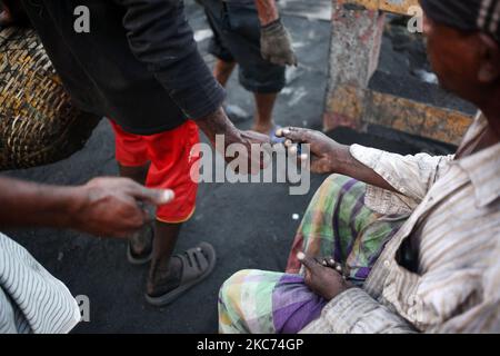 Die Arbeiter sammeln Münzen pro Korb, wenn sie am Freitag, den 08. Januar 2021, Kohle von einem Frachtschiff am Ufer des Flusses Buriganga in Dhaka, Bangladesch, entladen. Der derzeitige Verbrauch von Kohle für die Stromerzeugung liegt bei etwa 3,5 Millionen Tonnen pro Jahr für die beiden Kohlekraftwerke in Bangladesch, eines in Barapukuria (440MW) in Dinajpur und das andere in der neu in Betrieb genommenen Payra-Anlage (660MW) in Patuakhali. Nach dem Medienbericht würde der Kohleverbrauch für die Stromerzeugung im Jahr 2030 bei der Umsetzung des Masterplans 2016 10-mal höher und im Jahr 2041 20-mal höher sein als der Stockfoto