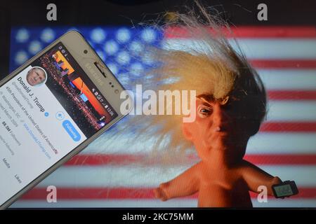 Donald Trumps Twitter-Account wird auf einem Handybildschirm neben einer Vinylpuppe angezeigt, auf der der US-Präsident Donald Trump vor der US-Flagge zu sehen ist. Am Samstag, den 9. Januar 2021, in Dublin, Irland. (Foto von Artur Widak/NurPhoto) Stockfoto