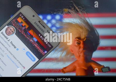 Donald Trumps Twitter-Account wird auf einem Handybildschirm neben einer Vinylpuppe angezeigt, auf der der US-Präsident Donald Trump vor der US-Flagge zu sehen ist. Am Samstag, den 9. Januar 2021, in Dublin, Irland. (Foto von Artur Widak/NurPhoto) Stockfoto