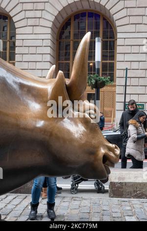 Die Bronze-Skulptur Charging Bull, auch bekannt als Wall Street Bull oder Bowling Green Bull in New York City, mit Touristen, die Fotos von ihr machen, da sie ein Wahrzeichen, ein Touristenziel ist, Eine beliebte Attraktion und Symbol für Wall Street und Financial District sowie mit aggressivem finanziellen Optimismus und Wohlstand, Reichtum und Glück, befindet sich am Broadway im Financial District von Manhattan. Es wurde von Arturo Di Modica im Jahr 1989 geschaffen. New York, USA am 2019. November (Foto von Nicolas Economou/NurPhoto) Stockfoto