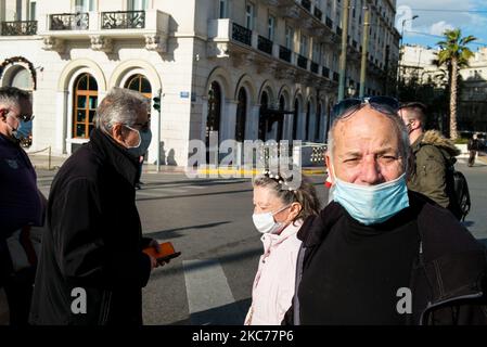 Maskierte Menschen passieren am 29. Dezember 2020 auf dem Syntagma-Platz die Straße in Athen, Griechenland (Foto: Vassilis A. Poularikas/NurPhoto) Stockfoto