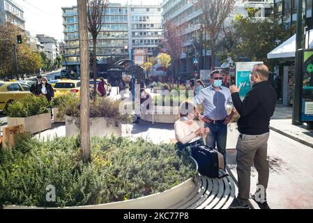 Menschen sitzen auf Bänken im Syntagma Squere und tragen ihre Masken aufgrund der Covid 19-Vorschriften am 29,2020. Dezember in Athen, Griechenland (Foto: Vassilis A. Poularikas/NurPhoto) Stockfoto