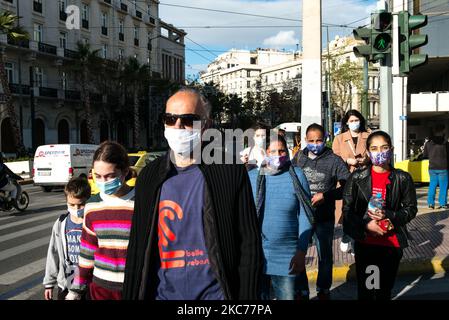 Maskierte Menschen passieren am 29. Dezember 2020 die Straße auf dem Syntagma-Platz in Athen, Griechenland (Foto: Vassilis A. Poularikas/NurPhoto) Stockfoto