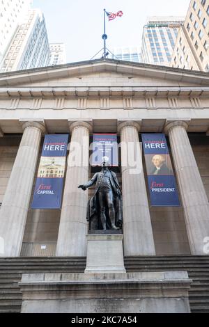 Eine Bronzestatue des ersten Präsidenten der Vereinigten Staaten von Amerika, George Washington, überblickt die Wall Street und die New York Stock Exchange NYSE von der Federal Hall, der ersten Hauptstadt, in New York City. George Washington wurde hier 1789 als Präsident eingeweiht, als NYC die Hauptstadt der Vereinigten Staaten war, bevor es 1790 nach Philadelphia, Pennsylvania, verlegt wurde. Installiert auf den vorderen Stufen des Federal Hall National Memorial an der Wall Street in New York City mit der Inschrift an der Basis der Skulptur GEORGE WASHINGTON GEBOREN 22. FEBRUAR 1732 WAKEFIELD WE Stockfoto