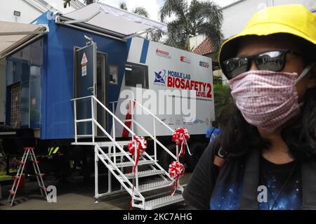 Eine Frau mit einer Maske steht in der Nähe eines Fahrzeugs des mobilen Labors BSL-2 (Biosicherheitsstufe 2) in Bogor, West Java, 11. Januar 2021. Biosicherheitsstufe 2 Mobiles Labor zur Unterstützung des Prozesses oder zur Verfolgung, Prüfung und Beschleunigung der Bemühungen, die Ausbreitung von Covid-19 in Bogor City zu stoppen (Foto von Adriana Adie/NurPhoto) Stockfoto
