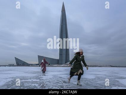 Mädchen laufen auf dem Eis des Finnischen Meerbusens in der Nähe des höchsten Wolkenkratzers Europas Lakhta Center, in Sankt Petersburg, Russland, am 11. Januar 2021 sank die Temperatur in Sankt Petersburg auf -12 Grad. (Foto von Valya Egorshin/NurPhoto) Stockfoto