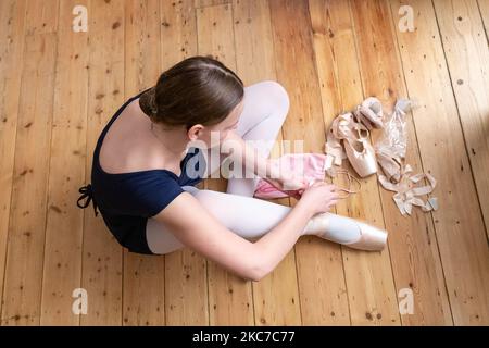 Die 14-jährige Gabi besucht am 11. Januar 2021 ihre Ballettklasse, die von ihrer Lehrerin an der Central School of Ballet in London, England, online geleitet wird. Gabis Gruppe trifft sich jede Woche, um Ballett zu trainieren. Die Schule bietet seit Beginn der Coronavirus-Pandemie Online-Kurse an. Anfang Januar wurden Tier-4-Beschränkungen eingeführt und alle Schulen in England wurden aufgrund des starken Anstiegs der Covid-19-Fälle geschlossen. (Foto von Dominika Zarzycka/NurPhoto) Stockfoto