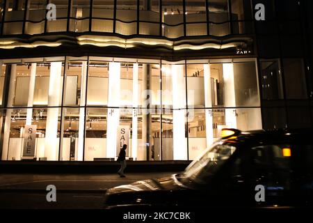 Ein Mann kommt an einer vorübergehend geschlossenen Filiale des Bekleidungshändlers Zara vorbei, während am 12. Januar 2021 in London, England, kurz vor 5pm, ein Taxi an einer fast menschenleeren Oxford Street vorbeifährt. England begann heute die zweite volle Woche seiner dritten nationalen Coronavirus-Sperre, die vom britischen Premierminister Boris Johnson aufgrund der Warnungen der Gesundheitsbehörden verhängt wurde, dass der National Health Service (NHS) bald mit Patienten mit Covid-19 überfordert werden könnte. (Foto von David Cliff/NurPhoto) Stockfoto