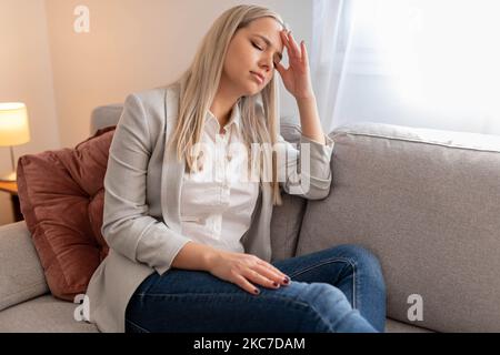 Porträt einer müden jungen Frau, die an Kopfschmerzen leidet Stockfoto