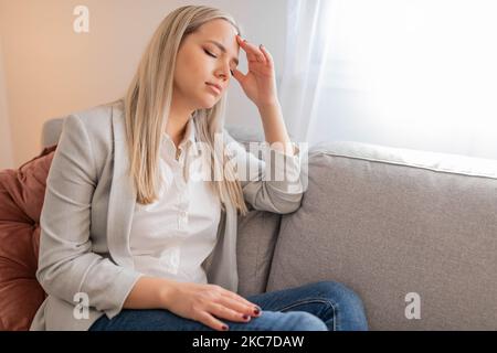 Porträt einer müden jungen Frau, die an Kopfschmerzen leidet Stockfoto