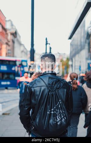Rückansicht eines Mannes mit schwarzer Lederjacke auf der Straße in Manchester, Großbritannien Stockfoto