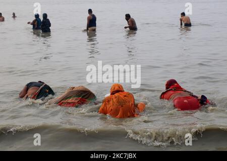 Ein hinduistischer Pilger taucht am Zusammenfluss von Ganges und der Bucht von Bengalen während des Gangasagar Mela anlässlich des Makar Sankranti, einem Tag, der in der hinduistischen Mythologie als von großer religiöser Bedeutung angesehen wird, auf der Insel Sagar, Rund 150 km südlich von Kalkutta am 14. Januar 2021. (Foto von Debajyoti Chakraborty/NurPhoto) Stockfoto