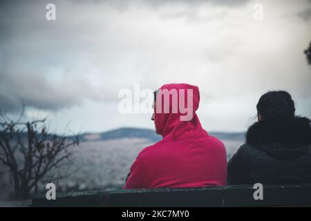 Griechen Jugendliche genießen die Aussicht auf Athen, Griechenland, am 16. Januar 2021 vom Lycabettus Hügel. Ein Spaziergang im Park ist eines der wenigen Dinge, die sie tun können, da alle Cafeterias, Bars und Einkaufszentren geschlossen bleiben. (Foto von Maria Chourdari/NurPhoto) Stockfoto