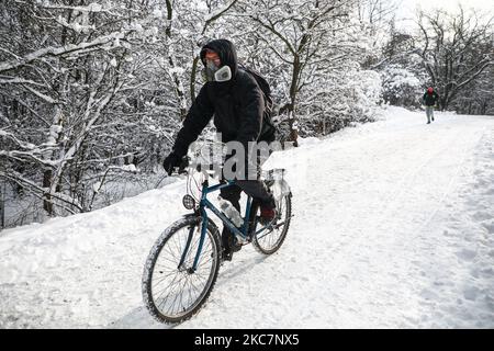 Ein Mann trägt eine Gesichtsmaske aufgrund der Coronavirus-Pandemie, während er an einem Wintertag in Krakau, Polen, mit dem Fahrrad fährt. 17. Januar 2021. (Foto von Beata Zawrzel/NurPhoto) Stockfoto