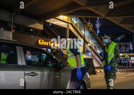 Malaysische Soldaten und Polizisten überprüfen Fahrzeuge an einer Straßensperre während der Umsetzung der Bewegungskontrollordnung (MCO 2,0) in Kuala Lumpur am 19. Januar 2021. Die malaysische Regierung verhängte vom 13. Bis 26. Januar erneut eine zweiwöchige Sperre für mehrere Bundesstaaten, nachdem die Zahl der Covid-19-Fälle sprunghaften Anstieg. (Foto von Mohd Firdaus/NurPhoto) Stockfoto