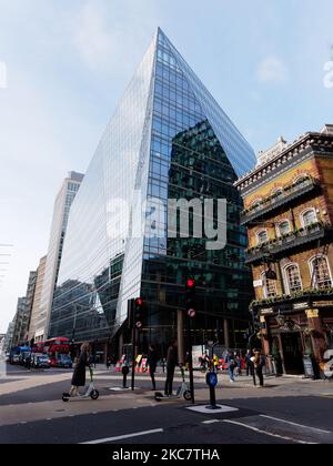 Leute auf Rollern an einer Fußgängerüberquerung auf der Victoria Street mit einem traditionellen Pub direkt hinter dem modernen Hochhaus. Nach London Stockfoto