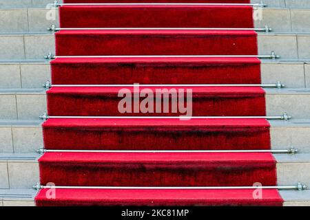 Roter Teppich auf einer Steintreppe vor dem Hotel, der zum Eingang des Gebäudes führt Stockfoto