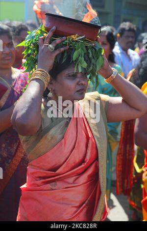 Die tamilische Hindu-Frau trägt einen Tontopf mit flammendem Kampfer, während sie an einer religiösen Prozession teilnimmt, die den Wagen begleitet, der das Idol von Lord Vinayagar während des Vinayagar Ther Thiruvizha Festivals in einem tamilischen Hindu-Tempel in Ontario, Kanada, am 23. Juli 2016 trägt. Dieses Festival ist Teil des 15 Tage langen Festivals, das Lord Ganesh ehrt, das mit diesem extravaganten Wagenzug gipfelt. (Foto von Creative Touch Imaging Ltd./NurPhoto) Stockfoto