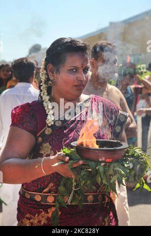 Die tamilische Hindu-Frau trägt einen Tontopf mit flammendem Kampfer, während sie an einer religiösen Prozession teilnimmt, die den Wagen begleitet, der das Idol von Lord Vinayagar während des Vinayagar Ther Thiruvizha Festivals in einem tamilischen Hindu-Tempel in Ontario, Kanada, am 23. Juli 2016 trägt. Dieses Festival ist Teil des 15 Tage langen Festivals, das Lord Ganesh ehrt, das mit diesem extravaganten Wagenzug gipfelt. (Foto von Creative Touch Imaging Ltd./NurPhoto) Stockfoto