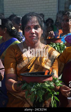 Die tamilische Hindu-Frau trägt einen Tontopf mit flammendem Kampfer, während sie an einer religiösen Prozession teilnimmt, die den Wagen begleitet, der das Idol von Lord Vinayagar während des Vinayagar Ther Thiruvizha Festivals in einem tamilischen Hindu-Tempel in Ontario, Kanada, am 23. Juli 2016 trägt. Dieses Festival ist Teil des 15 Tage langen Festivals, das Lord Ganesh ehrt, das mit diesem extravaganten Wagenzug gipfelt. (Foto von Creative Touch Imaging Ltd./NurPhoto) Stockfoto