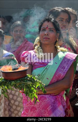 Die tamilische Hindu-Frau trägt einen Tontopf mit flammendem Kampfer, während sie an einer religiösen Prozession teilnimmt, die den Wagen begleitet, der das Idol von Lord Vinayagar während des Vinayagar Ther Thiruvizha Festivals in einem tamilischen Hindu-Tempel in Ontario, Kanada, am 23. Juli 2016 trägt. Dieses Festival ist Teil des 15 Tage langen Festivals, das Lord Ganesh ehrt, das mit diesem extravaganten Wagenzug gipfelt. (Foto von Creative Touch Imaging Ltd./NurPhoto) Stockfoto