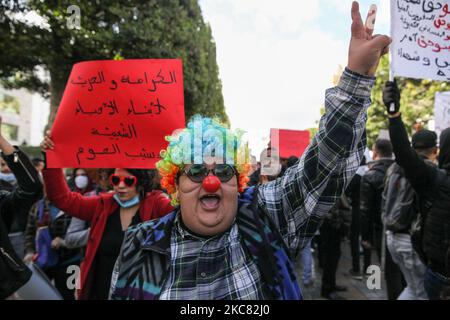 Eine als Clown getarnte Protesterin macht ein Siegeszeichen, als sie an einer Demonstration in der Hauptstadt Tunis teilnahm, um zum Sturz des Regimes zu rufen und gegen die „Polizeigewalt“ zu protestieren, die während der letzten nächtlichen Proteste im Land eingesetzt wurde. Sie forderten die Freilassung der jungen Demonstranten, die von der Polizei verhaftet wurden. Demonstranten protestierten auch gegen die Erklärung des Präsidenten des Shura-Rates der islamistischen Ennahdha-Partei Tunesiens, Abdelkarim Harouni, der sagte: „Die Kinder von Ennahdha werden vor Ort sein, um die Sicherheitskräfte zu unterstützen“. Proteste Stockfoto