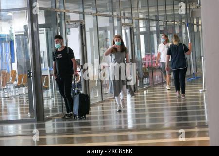 Passagiere mit Gesichtsmasken, Gesichtsschutz, Handschuhen und anderen Sicherheitsmaßnahmen werden vor dem Abflug am internationalen Flughafen Thessaloniki Makedonia SKG LGTS während der Ära der Coronavirus-Pandemie Covid-19 im Flughafenterminal gesehen. Es kommt eine zweite Welle, während die Fälle zunehmen, Gesichtsmask obligatorisch wird, soziale Distanzierungsmaßnahmen und Desinfektionsmittel überall sind, während neue Sperren oder Mini-Lockdown, Verkehrsverbot, Reisebeschränkungen oder Ausgangssperre von Regierungen auferlegt werden. Die Verwendung eines Facemask- und eines PCR-Negativtests sowie eines mehrfachen Schnelltests ist erforderlich Stockfoto