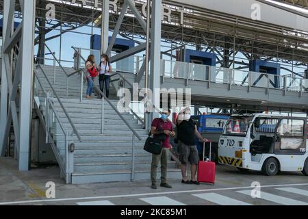 Passagiere mit Gesichtsmasken, Gesichtsschutz, Handschuhen und anderen Sicherheitsmaßnahmen werden vor dem Abflug am internationalen Flughafen Thessaloniki Makedonia SKG LGTS während der Ära der Coronavirus-Pandemie Covid-19 im Flughafenterminal gesehen. Es kommt eine zweite Welle, während die Fälle zunehmen, Gesichtsmask obligatorisch wird, soziale Distanzierungsmaßnahmen und Desinfektionsmittel überall sind, während neue Sperren oder Mini-Lockdown, Verkehrsverbot, Reisebeschränkungen oder Ausgangssperre von Regierungen auferlegt werden. Die Verwendung eines Facemask- und eines PCR-Negativtests sowie eines mehrfachen Schnelltests ist erforderlich Stockfoto