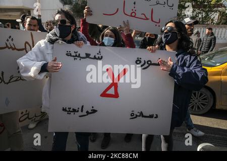 Junge Demonstranten, die in einem arabischen Transparent mit der Aufschrift „Volksrevolution, Nein zu Islamisten und Destourianern“ protestieren, ‘während eines protestmarsches, der im beliebten und harten Viertel Hay Ettadhamen, einer der bevölkerungsreichsten Städte Tunis, begann, Und ging in Richtung Bardo City in Tunis, um gegen die Brutalität der Polizei, die Marginalisierung und die wirtschaftliche und soziale Krise im Land zu protestieren. Demonstranten hatten auch die Freilassung von Jugendlichen gefordert, die während der letzten nächtlichen Proteste, bei denen sie mit den Sicherheitskräften zusammenprallten, von der Polizei verhaftet wurden. Sicherheitskräfte Stockfoto
