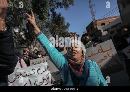 Eine Protesterin macht das Siegeszeichen (V-Zeichen), als sie während eines protestmarsches, der in dem beliebten und schwierigen Viertel Hay Ettadhamen, einer der bevölkerungsreichsten Städte Tunis, begann, Anti-Regierungs-Slogans ruft, Und ging in Richtung Bardo City in Tunis, um gegen die Brutalität der Polizei, die Marginalisierung und die wirtschaftliche und soziale Krise im Land zu protestieren. Demonstranten hatten auch die Freilassung von Jugendlichen gefordert, die während der letzten nächtlichen Proteste, bei denen sie mit den Sicherheitskräften zusammenprallten, von der Polizei verhaftet wurden. Die Sicherheitskräfte verhinderten, dass sie in Fron demonstrierten Stockfoto