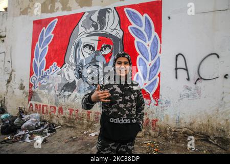 Ein Teenager posiert für Bilder vor einer Wand, auf der eine Zeichnung eines Mannes mit Gasmaske aufgraffiert ist, im beliebten und harten Viertel Hay Ettadhamen, einer der bevölkerungsreichsten Städte Tunis, während eines protestmarsches in Richtung Bardo in Tunis, Gegen die Brutalität der Polizei, die Marginalisierung und die wirtschaftliche und soziale Krise im Land zu protestieren. Demonstranten hatten auch die Freilassung von Jugendlichen gefordert, die während der letzten nächtlichen Proteste, bei denen sie mit den Sicherheitskräften zusammenprallten, von der Polizei verhaftet wurden. Sicherheitskräfte verhinderten, dass sie in Fr. Stockfoto