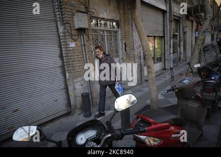 Ein Iraner geht entlang einer Straße in der Nähe von Teherans traditionellem Grand Basar inmitten des COVID-19-Ausbruchs im Iran am 27. Januar 2021. (Foto von Morteza Nikoubazl/NurPhoto) Stockfoto