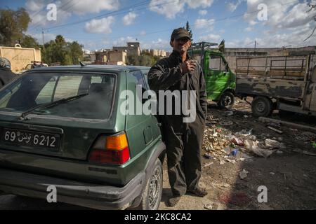 Ein Zigarettenraucher posiert für Bilder in der Straße eines schwierigen Viertels der beliebten Stadt Ettadhamen, die zu den bevölkerungsreichsten Städten der Hauptstadt Tunis gehört. Ettadhamen City, dessen Name „Solidarität“ bedeutet, wurde von den Wellen der internen Migration (Arme, Kleinbauern und Arbeitslose) gebildet, die Tunesien Anfang 1950s kennzeichneten. Die Jugend des Viertels spielte eine zentrale Rolle in der Revolution von 2011, die Präsident Zine el-Abidine Ben Ali stürzte. Seitdem hat sich die Situation verschlechtert: Unsicherheit, Armut, steigende Lebenshaltungskosten, Arbeitslosigkeit, Schulabbruch, Stockfoto