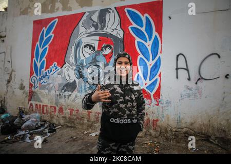 Ein Teenager macht das Siegeszeichen (V-Zeichen), während er vor einer Wand für Bilder posiert, auf der eine Zeichnung eines Mannes mit Gasmaske in einem harten Viertel der beliebten Stadt Ettadhamen graffiert ist, Die Stadt ist eine der bevölkerungsreichsten Städte der Hauptstadt Tunis. Ettadhamen City, dessen Name „Solidarität“ bedeutet, wurde von den Wellen der internen Migration (Arme, Kleinbauern und Arbeitslose) gebildet, die Tunesien Anfang 1950s kennzeichneten. Die Jugend des Viertels spielte eine zentrale Rolle in der Revolution von 2011, die Präsident Zine el-Abidine Ben Ali stürzte. Seitdem hat sich die Situation verschlechtert: pr Stockfoto